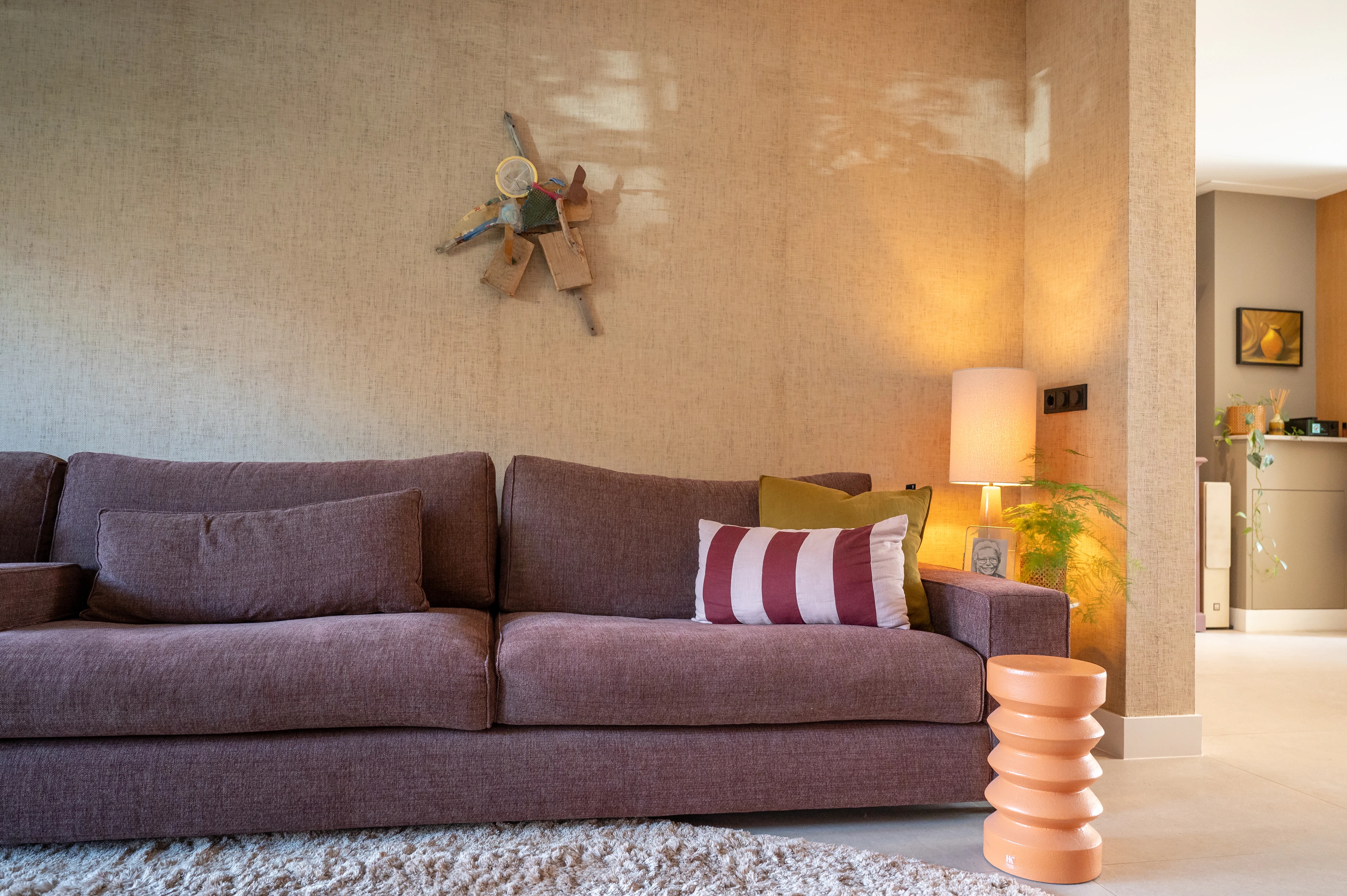 Zithoek met paarse bank en zacht verlichte wand